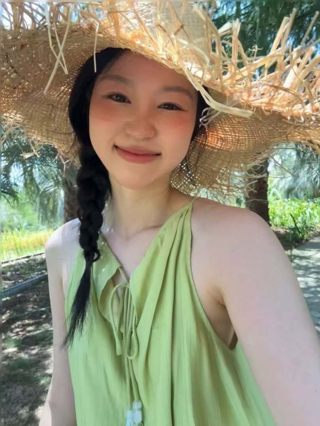 阳光下戴着草帽微笑的照片